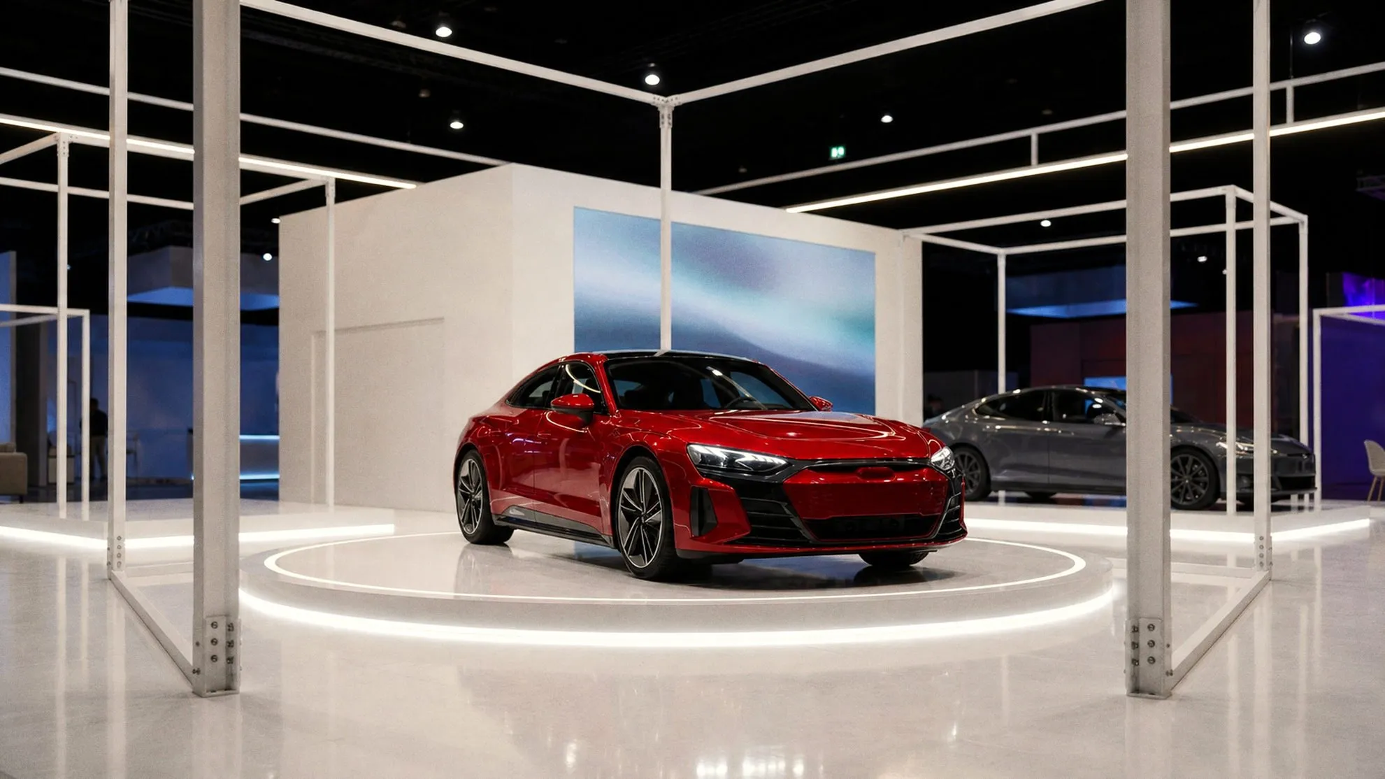 Exhibition stand with a red car on a white turntable under a suspended frame of light