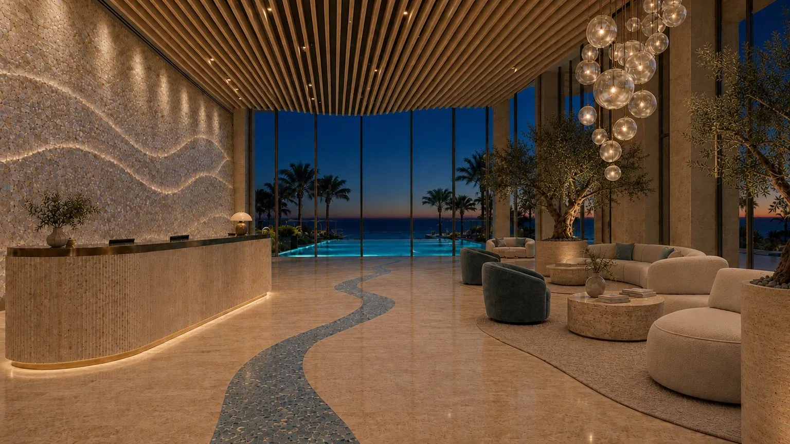 The lobby at dusk, lamp-lit, with the terrazzo band leading to the pool terrace