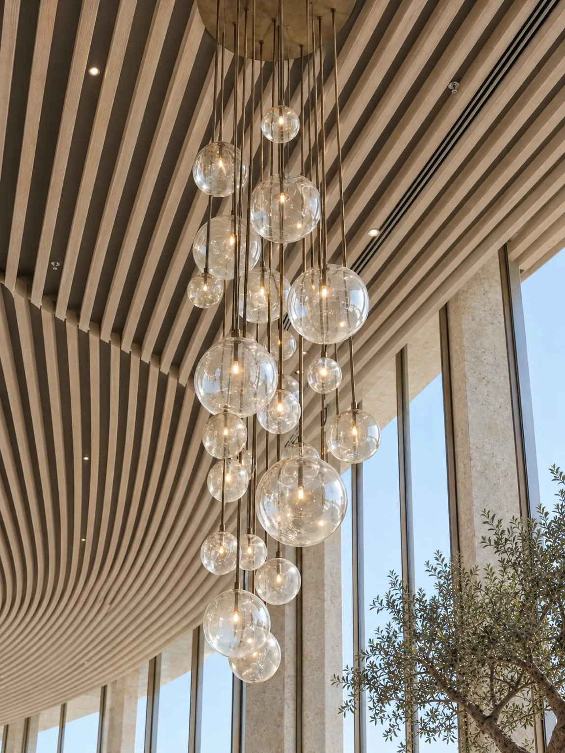 Cluster of hand-blown glass pendants in front of the ceiling baffles