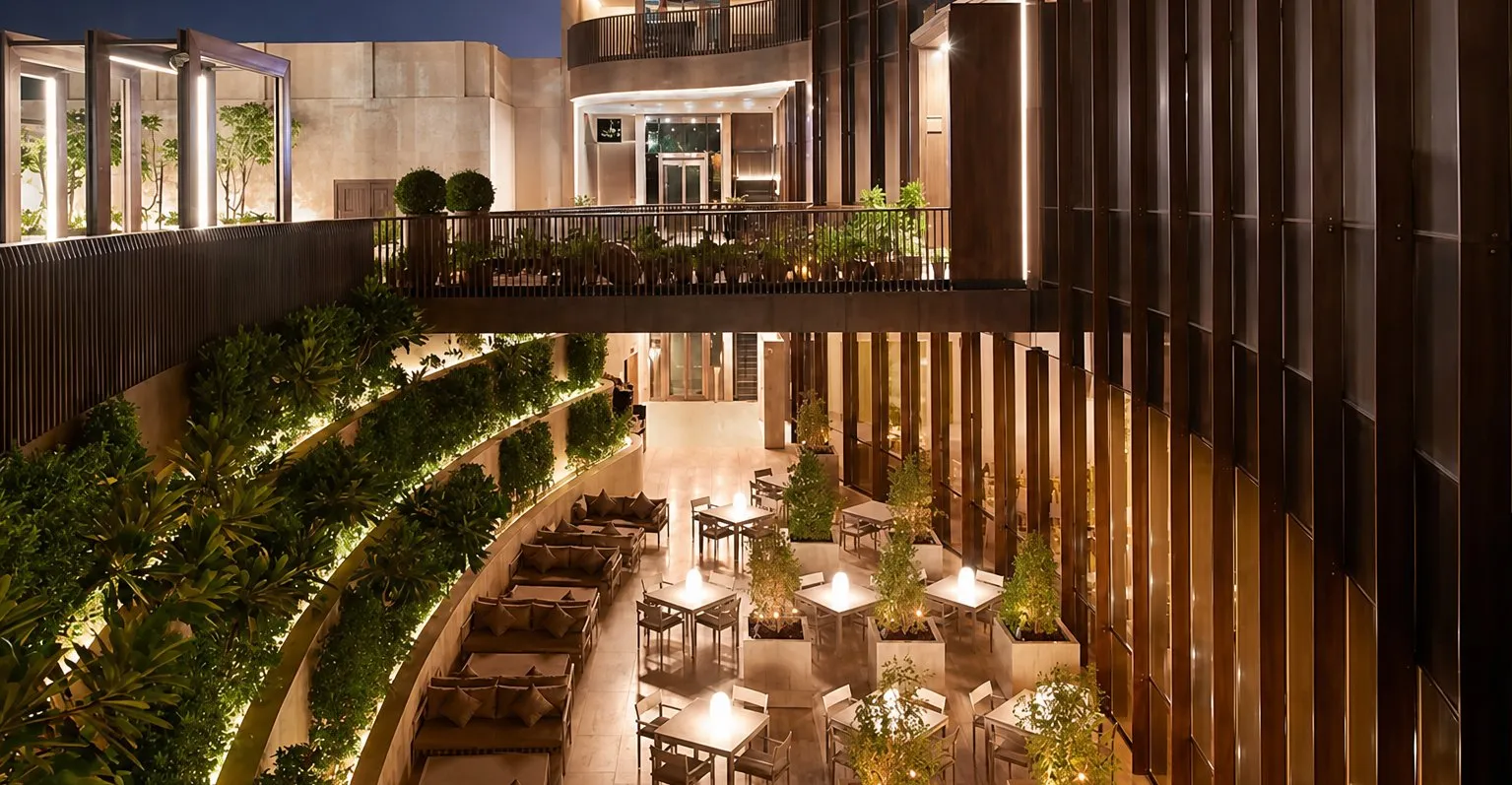 Outdoor terrace with planted screens and string lights